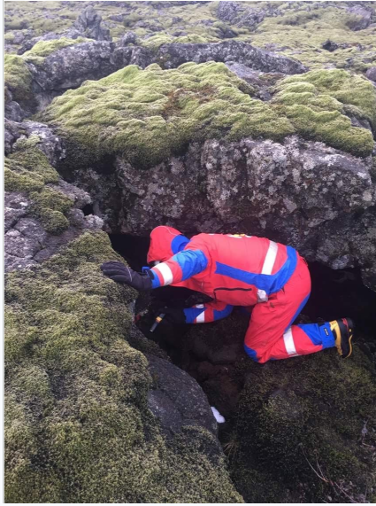 Search and rescue volunteer checking rocky terrain